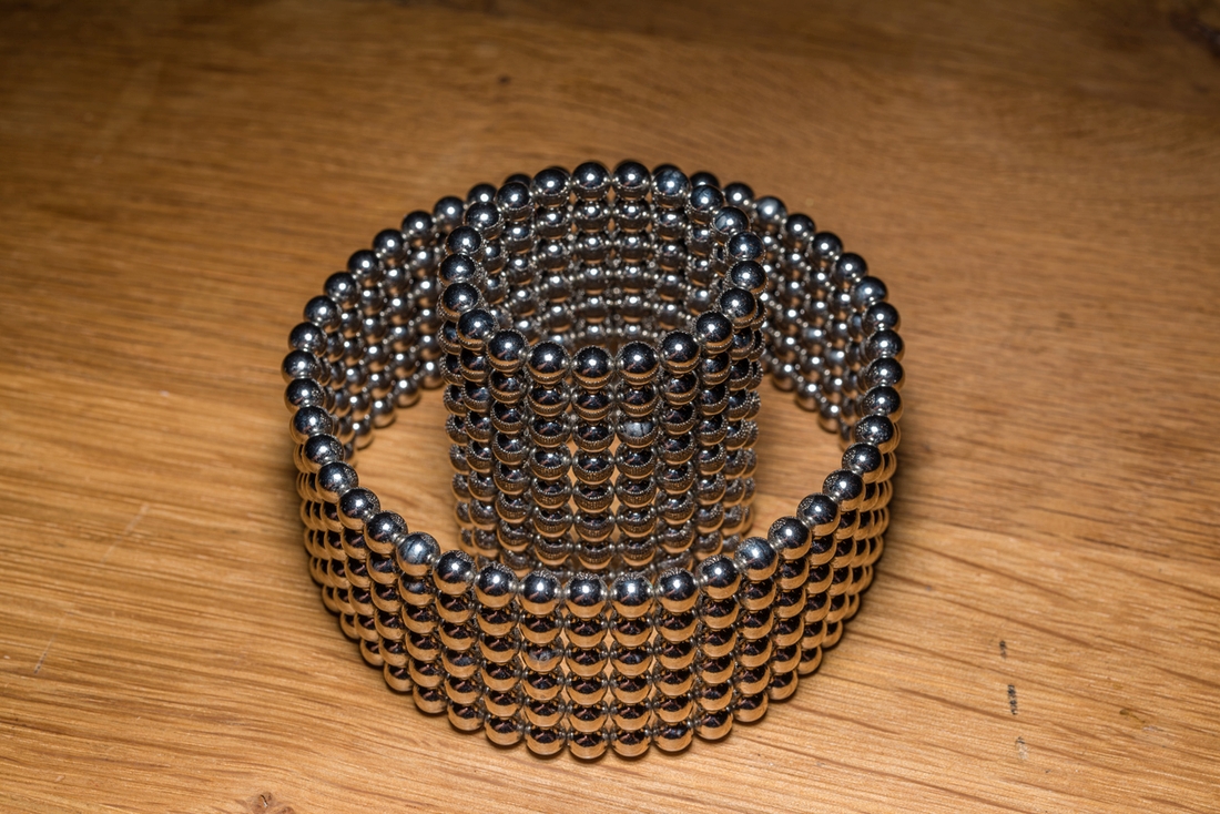 Funny thinking out of the box in toy magnet cubes and balls isolated on a wooden background