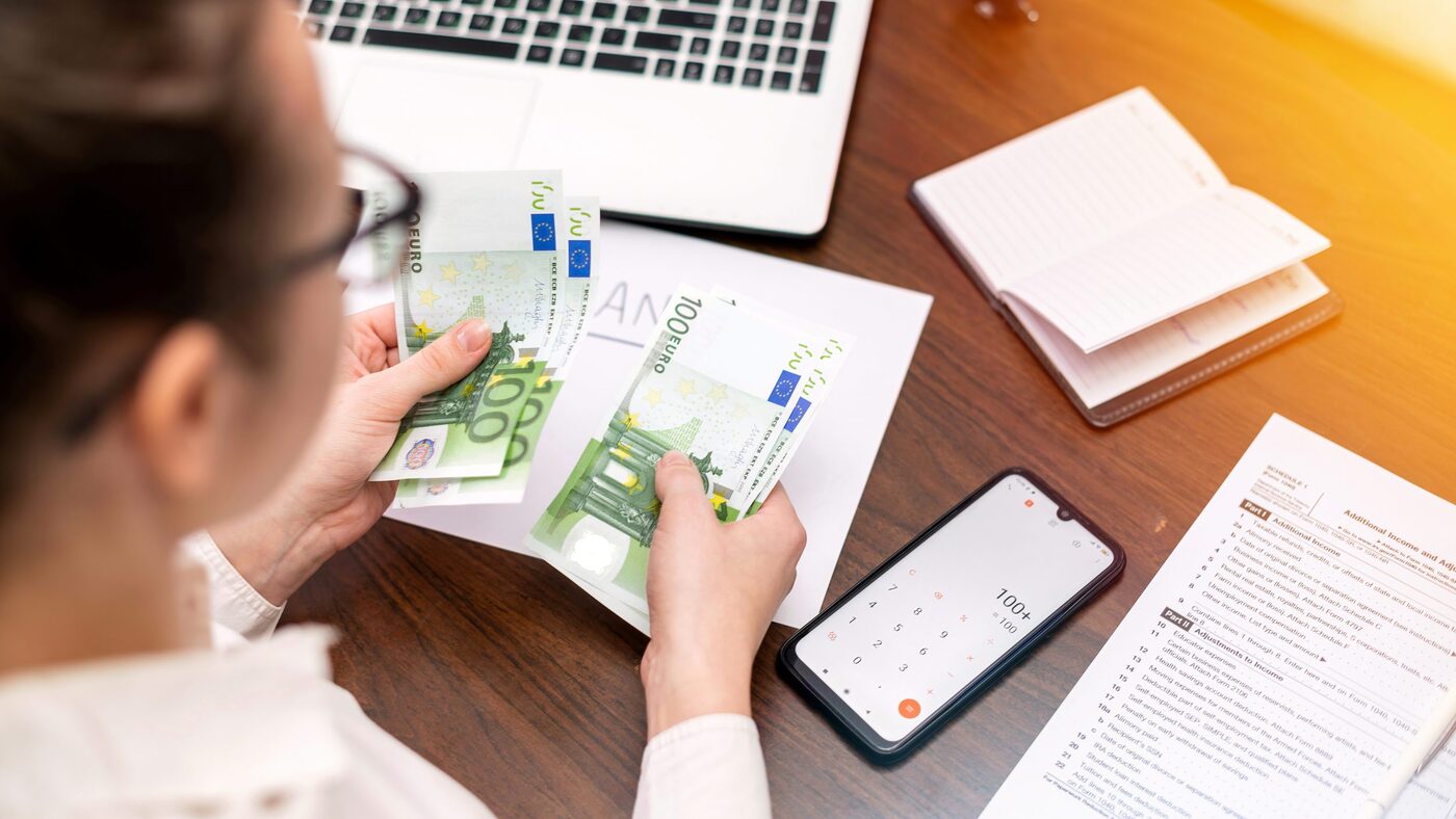 woman working with finances counting money table smertphone notepad